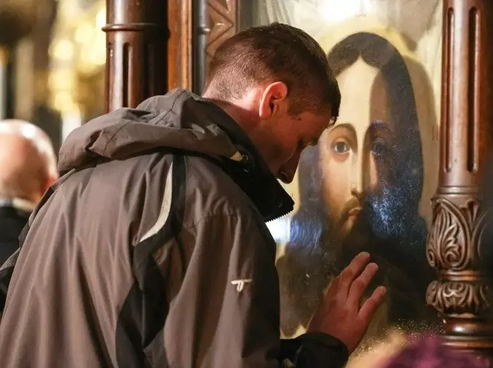 Мужчина молится перед иконой