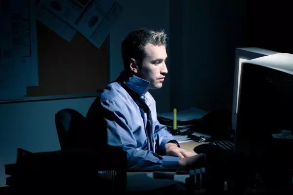 Мужчина сидит ночью за компьютером