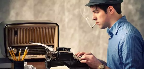 Мужчина печатает на пишущей машинке