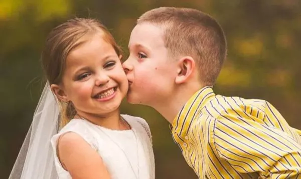 Мальчик целует девушку в щеку