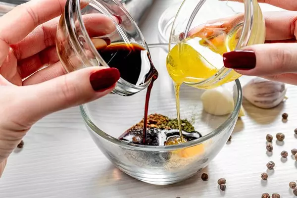 Крупный план женских рук, наливающих мед и соевый соус в чашу со специями - Основной запрет