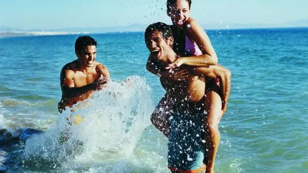 Девушка и двое молодых людей плавают в озере