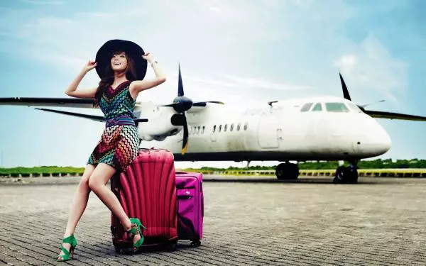 Девушка с чемоданами возле самолета