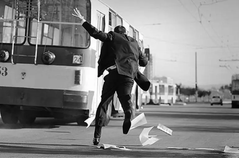 Мужчина бежит за троллейбусом