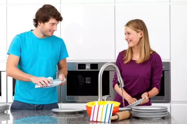 Муж и жена моют посуду