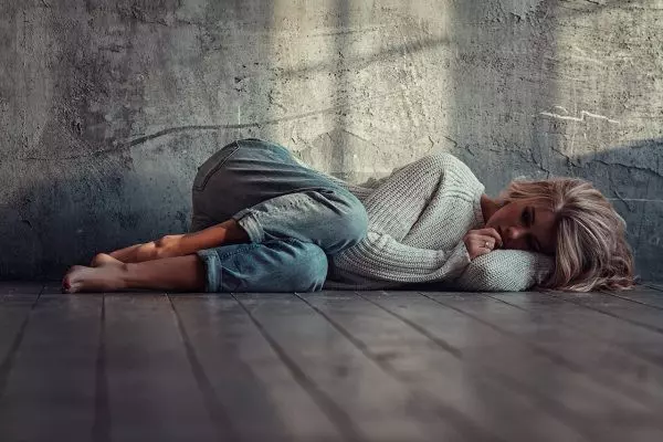 Грустная девушка лежит на полу