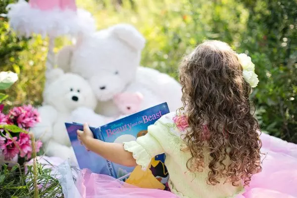 Девочка читает сказку своим игрушкам