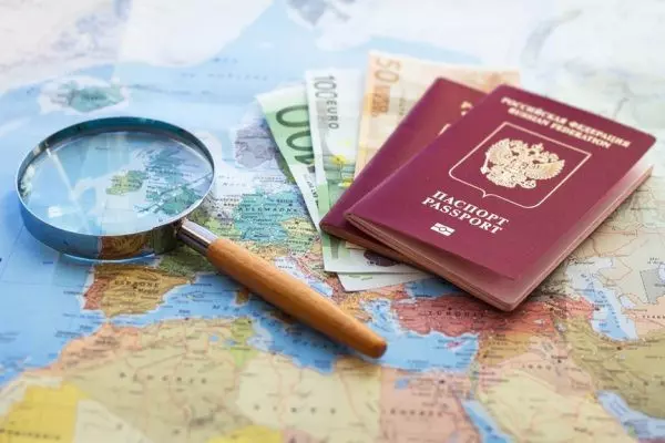 Паспорт, деньги и лупа на карте