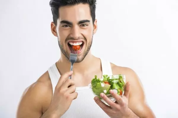 Мужчина ест овощи