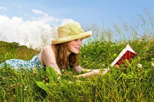 Девушка читает книгу на природе