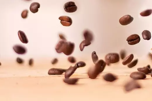 кофейные зерна падают на стол